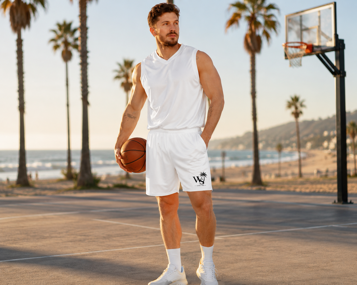 WaveSurfing™ Unisex Mesh Shorts worn by an athlete on a beach basketball court at sunset, featuring lightweight recycled performance fabric, coastal lifestyle design, and active beachwear style.