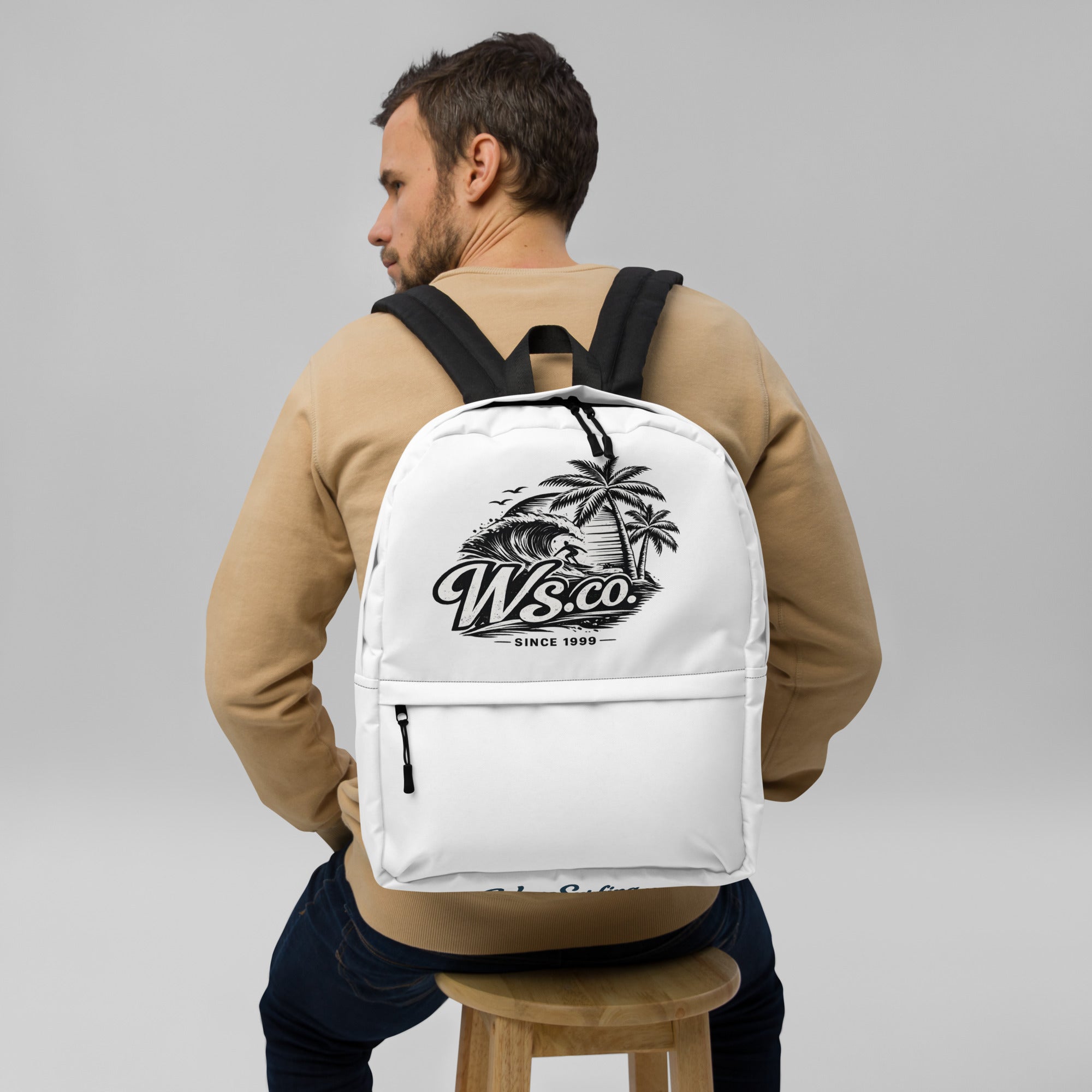 White WaveSurfing™ backpack with a bold surf-inspired logo worn by a student heading to school. Durable, water-resistant design with padded straps and a spacious compartment for books, a laptop, and everyday essentials.